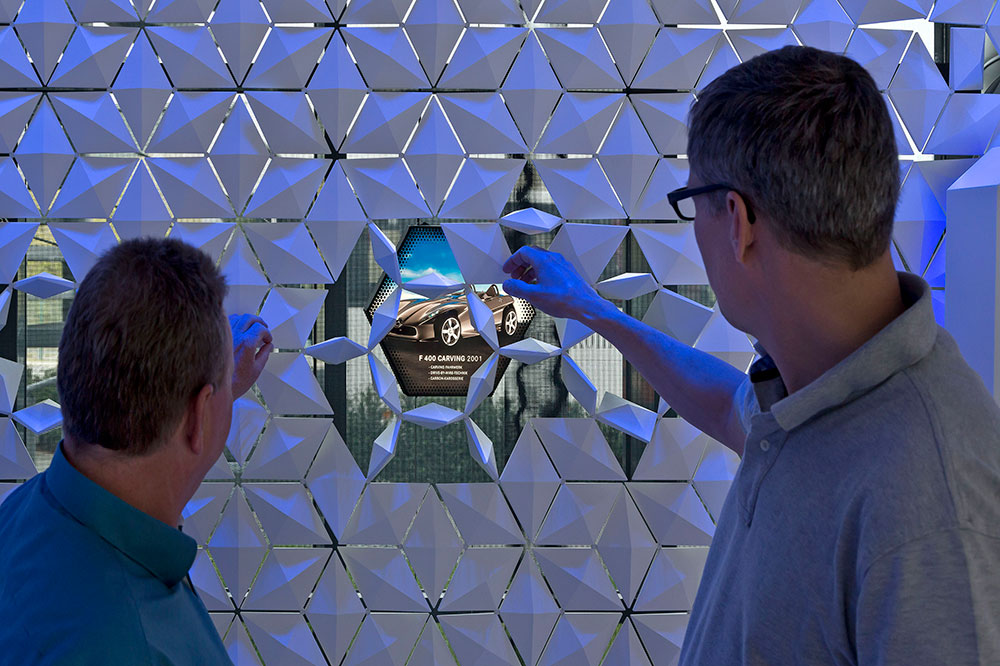 Visitors interacting with Facet tactile modular exhibition wall system