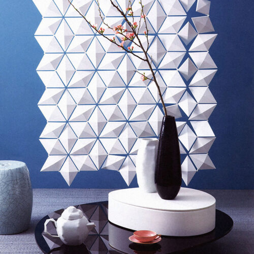 Divisorio di design Facet utilizzato come sfondo geometrico nella fotografia d’interni con vaso e composizione still-life