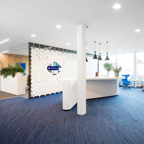 Grande partizione per ufficio con branding integrato nell’area reception di un open space