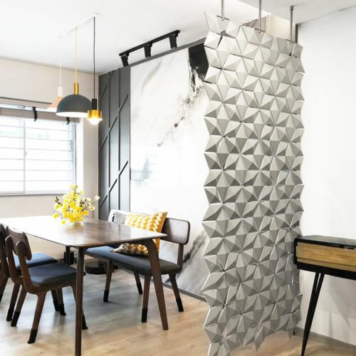 Sala de jantar com uma divisória suspensa Facet em Cinzento Pérola e suspensões de 20 cm a separar a zona de jantar numa casa moderna em Singapura.