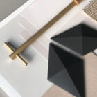 Anodized gold suspension with Facet hanging room divider in a designer interior setting