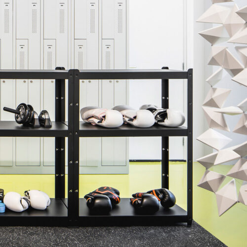Schermo divisorio su misura Facet in bianco, che crea una separazione semi-trasparente tra l’area relax e la zona workout di Workoutclub Rotterdam