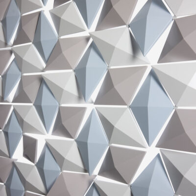 Nahaufnahme des Facet-Raumteilers in Blassblau, Perlgrau und Weiß mit geometrischen Elementen, die in unterschiedlichen Winkeln gedreht sind.